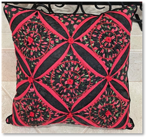 A pillow with red and black design and candles

Description automatically generated